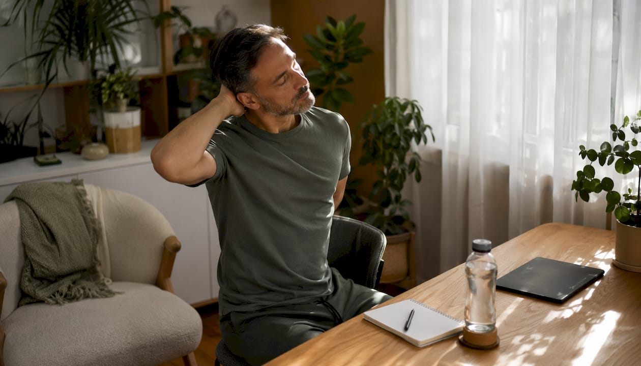 Middle-aged man stretching indoors