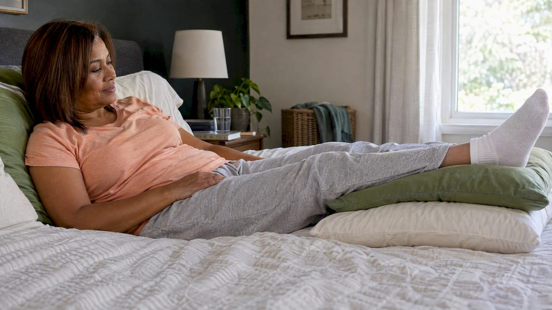 Woman elevates her recovering leg on pillows