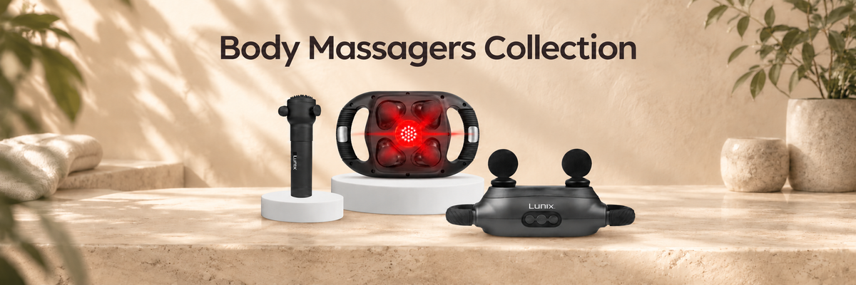 Three Lunix body massagers displayed on a beige stone surface with a warm neutral background and text reading 'Body Massagers Collection' at the top. The products include a black handheld massager on a white stand, a red-and-black heat-and-massage device on a white base, and a black neck/shoulder massager.