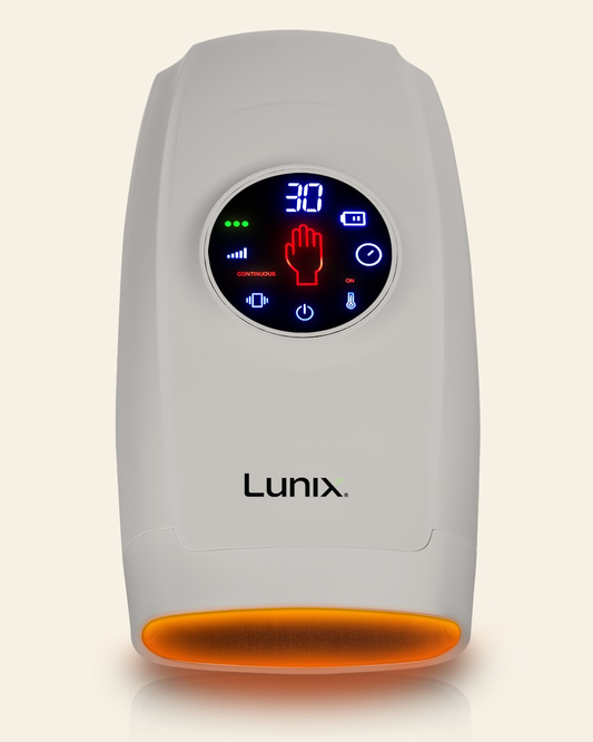 A gray Lunix hand massager with a circular digital display showing blue and red interface icons, set against a light beige background.