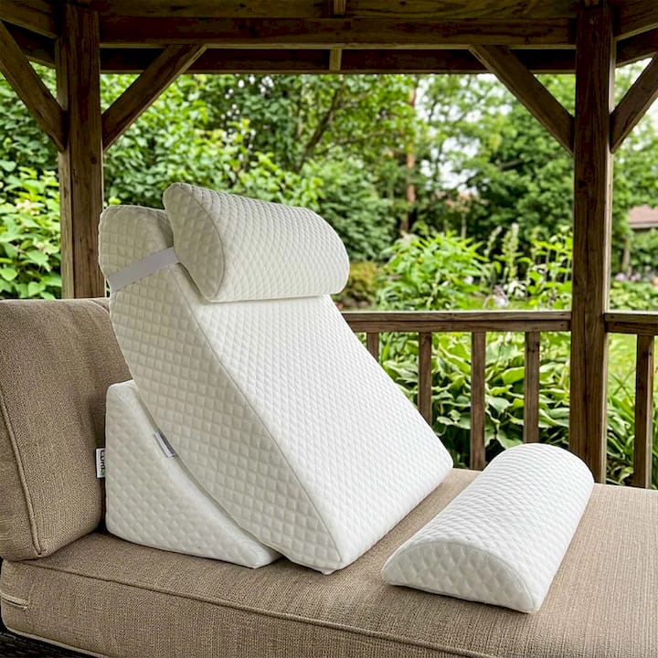 White Bed Wedge Pillow placed on a brown couch in an outdoor setting.